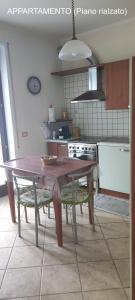 a kitchen with a wooden table and a table and chairs at Dimora Nonna Angela in Alberobello