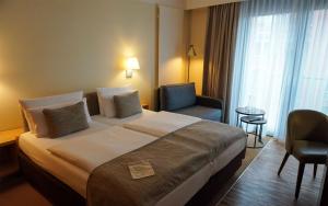a hotel room with a large bed and a chair at centrovital Hotel Berlin in Berlin +43 photos