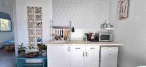a white kitchen with a sink and a microwave at Nof Beresheet suites in Neot Golan