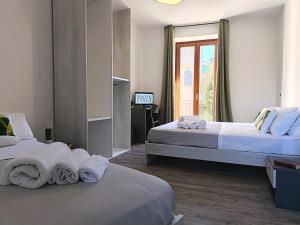 a hotel room with two beds with towels on them at B&B A' Kiazza in Buompietro