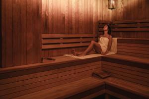 a woman is sitting in a sauna at Ośrodek Uzdrowiskowy Biawena in Wysowa-Zdrój