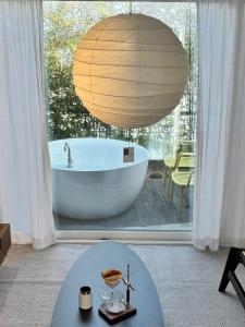 a bath tub in a bathroom with a large window at Jeju Byeolkkum Pension in Jeju