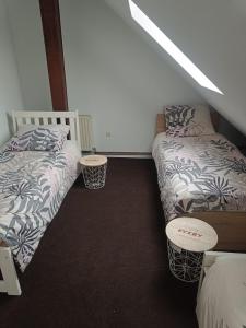 a room with two beds and two tables in it at Paula Apart in Wadowice +3 photos