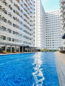 a large swimming pool in front of a large building at Sweetluxx - SMDC Green 2 Residences Staycation in Dasmariñas