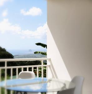 a table and chairs on a balcony with a view of the ocean at Appartement Ti Colibri in Rivière-Salée