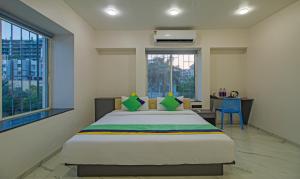 a bedroom with a bed and a desk and a window at Treebo Atithi Comforts Inn in Pune +26 photos