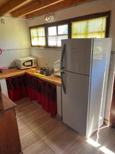 a kitchen with a white refrigerator and a sink at Casita Los Samoyedos in Lago Puelo