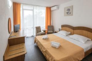 ein Schlafzimmer mit Bett, Schreibtisch und Fernseher in der Unterkunft Hotel Siret Saturn in Saturn