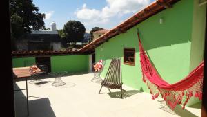 a green building with a hammock on a patio at Pousada Esmeralda in Salvador