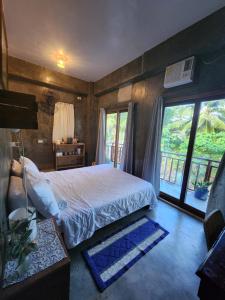 a bedroom with a bed and a large window at Balay Yuhom in General Luna