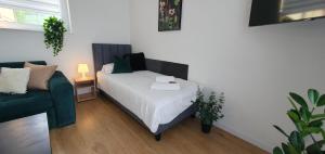 a small bedroom with a bed and a couch at VESTA Apartamenty M52 Free parking in Szczecin