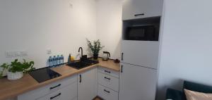 a kitchen with a white refrigerator and a counter top at VESTA Apartamenty M52 Free parking in Szczecin