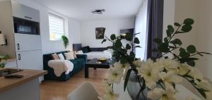 a living room with a couch and a vase of flowers at VESTA Apartamenty M52 Free parking in Szczecin +185 photos