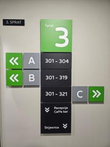 a sign on a wall with arrows on it at Nest 316 Bela Reka Kopaonik in Brzeće