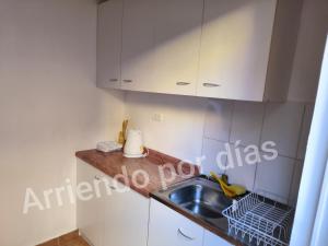 a kitchen with white cabinets and a sink at Casa Sierra Nevada in Antofagasta +7 photos