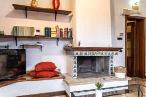 a living room with a fireplace with red pillows at Italian Experience-Casa Miramonti in Perugia