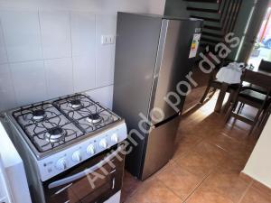 a kitchen with a stove and a refrigerator at Casa Sierra Nevada in Antofagasta