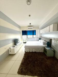 a bedroom with a large bed and a rug at 2 Bedroom Condo SMDC Breeze Residences in Manila
