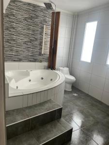 a white bathroom with a tub and a toilet at dpto lofalu in Gobernador Gregores