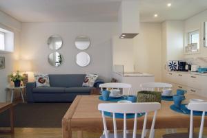 een woonkamer met een bank en een tafel en stoelen bij Spot Apartments Ceuta in Porto