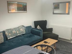 a living room with a green couch and a chair at Folly Field in Haworth