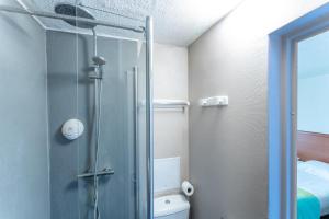a bathroom with a toilet and a glass shower at Bhoma Budget Troyes aéroport in Troyes