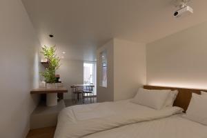 a white bedroom with a bed and a table at 루아호텔 in Seoul