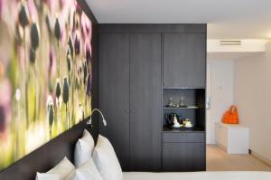 a bedroom with a bed with a painting on the wall at Flanders Hotel in Bruges
