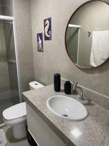a bathroom with a sink and a toilet and a mirror at Flat Garden 02-A - Beach Class Verano - Porto de Galinhas in Ipojuca +19 photos