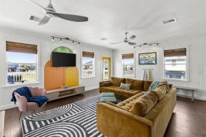 a living room with a couch and a tv at Once Upon A Tide in Bolivar Peninsula