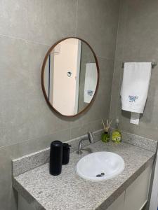 a bathroom counter with a sink and a mirror at Flat Garden 02-A - Beach Class Verano - Porto de Galinhas in Ipojuca