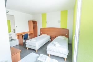 a hospital room with two beds and a mirror at Bhoma Budget Troyes aéroport in Troyes