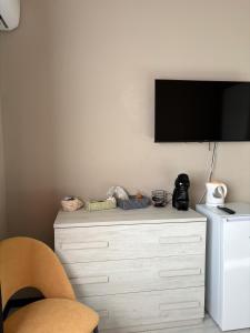 a white dresser with a television on a wall at Dimora Alta in Olbia