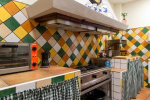 a kitchen with a stove and a colorful tiled wall at La Posada de Maruchi in Pozáldez +66 photos