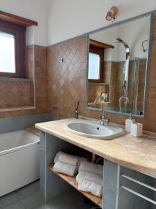 a bathroom with a sink and a tub at Dimora Alta in Olbia