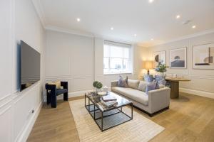 a living room with a couch and a tv at Buckingham & Lloyds Knightsbridge in London
