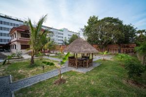 a garden with a gazebo and a building at Teko Paradise and Kitchen in Phumĭ Kruŏs