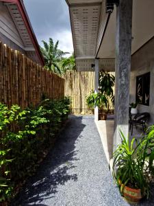 a porch of a house with a fence and plants at Krabi Aonang happy resort in Ao Nam Mao