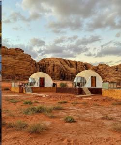two domes in the desert with rocks in the background at Golden Camp- wadi rum in Wadi Rum +12 photos