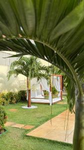 a view of a garden with palm trees and a tent at Pousada Linhares in Canoa Quebrada
