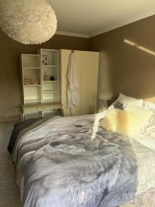 a bedroom with a large bed with a painting on it at Villa des Bois Sauvages in Liège