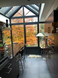 a kitchen with a large window and a counter with chairs at Villa des Bois Sauvages in Liège