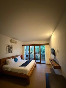 a bedroom with a large bed and a balcony at The Secreet Garden Hotel in Denpasar