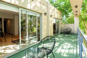 a balcony with two chairs and tables and windows at Feel Buenos Aires Apartments in Buenos Aires