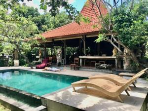 a person laying on the ground next to a swimming pool at The Secreet Garden Hotel in Denpasar +18 photos