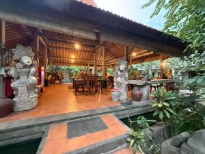 an outdoor dining area of a house with a wooden pavilion at The Secreet Garden Hotel in Denpasar