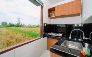 a kitchen with a window with a view of a field at Putra House Ubud in Ubud