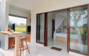a bedroom with a bed and a desk in a room at Putra House Ubud in Ubud