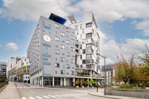 a tall white building with a clock on it at Pestana Brussels Schuman in Brussels