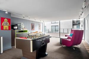 a room with a game table and a red chair at Pestana Brussels Schuman in Brussels